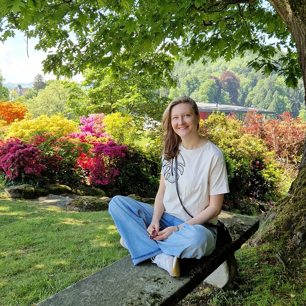 Adela in a vibrant garden with colorful flowers