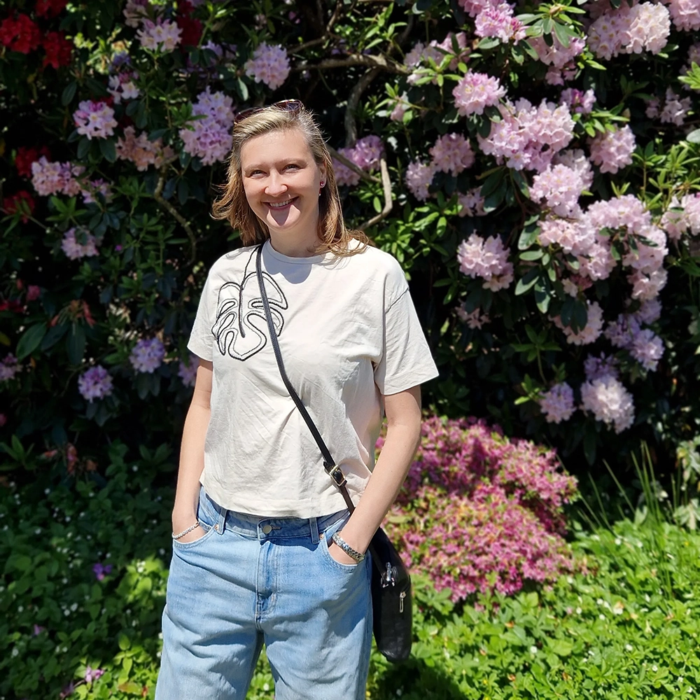 Adela standing joyfully among beautiful purple flowers