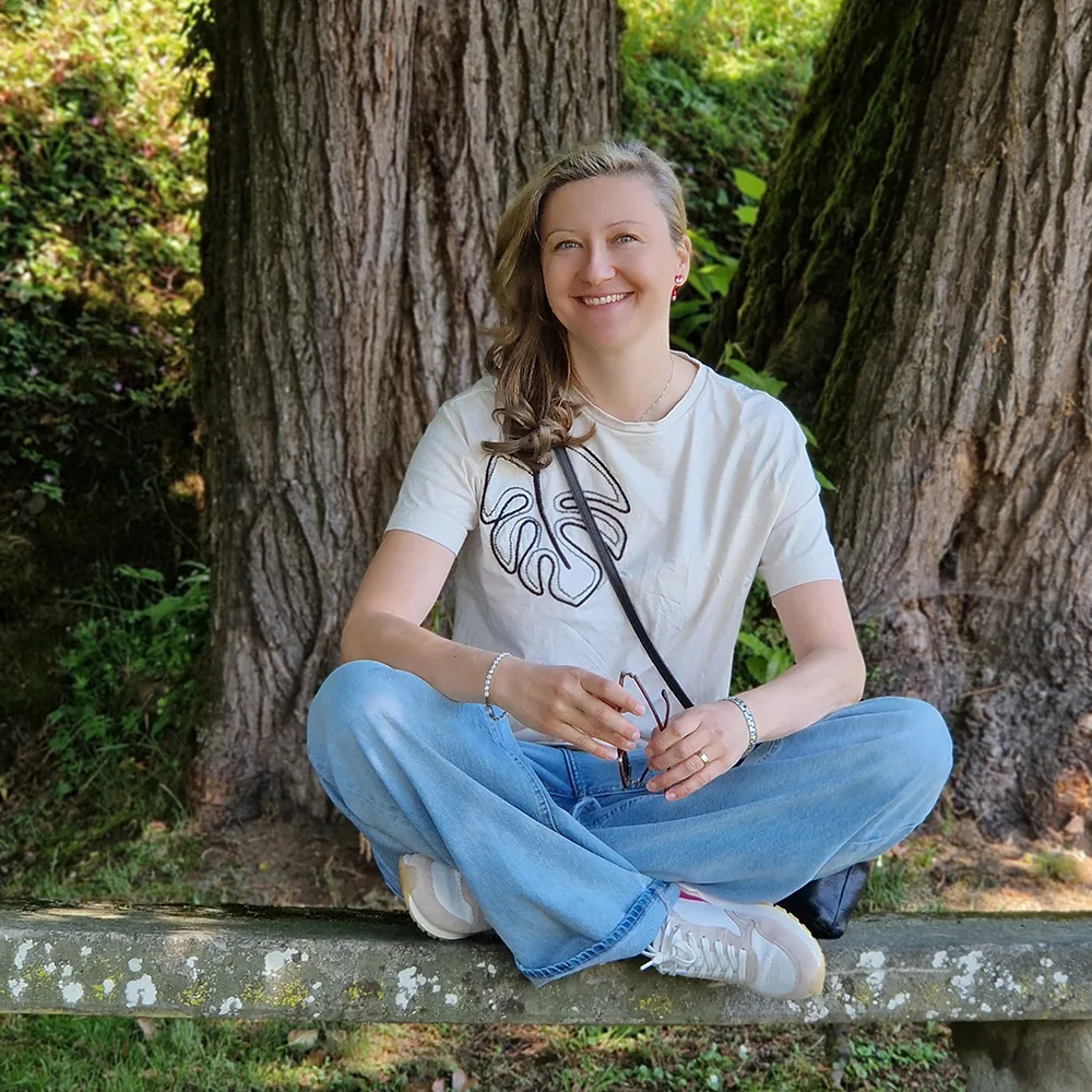 Adela sitting peacefully in nature surrounded by trees