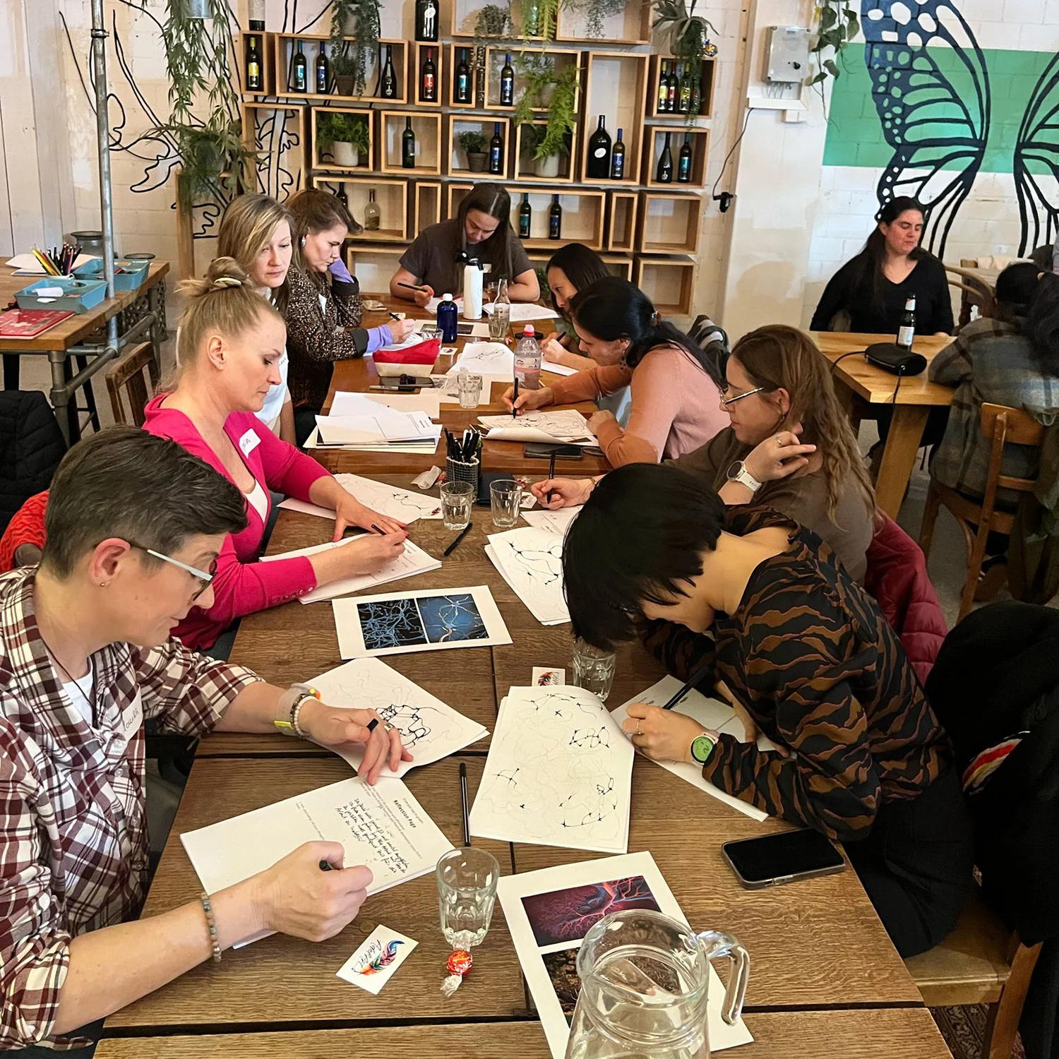 Group neurographica workshop with multiple participants at wooden tables