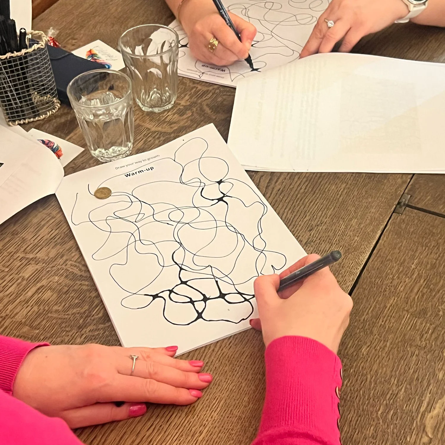 Hands working on neurographica warm-up exercises with flowing lines