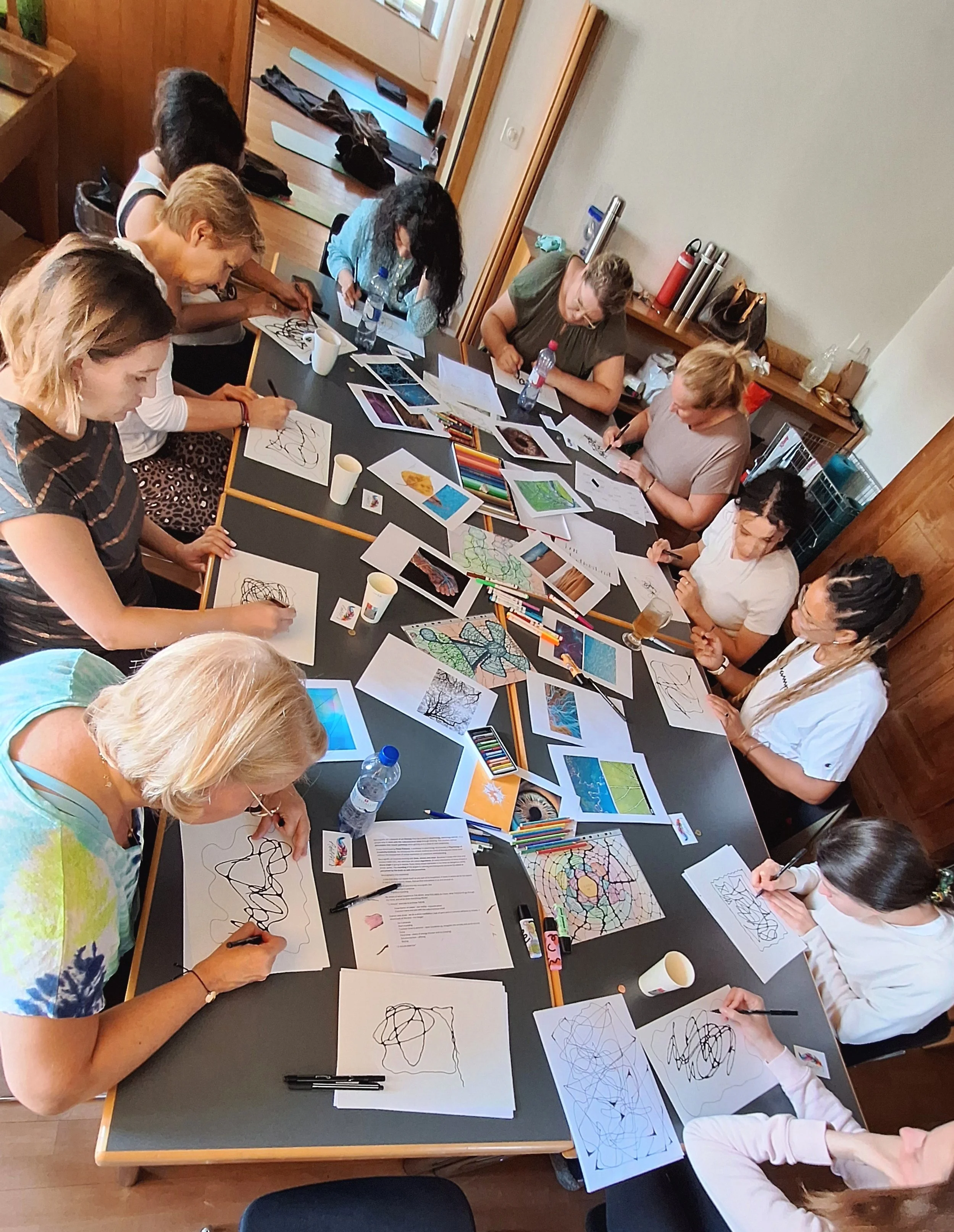 Neurographica workshop participants working on art around a table